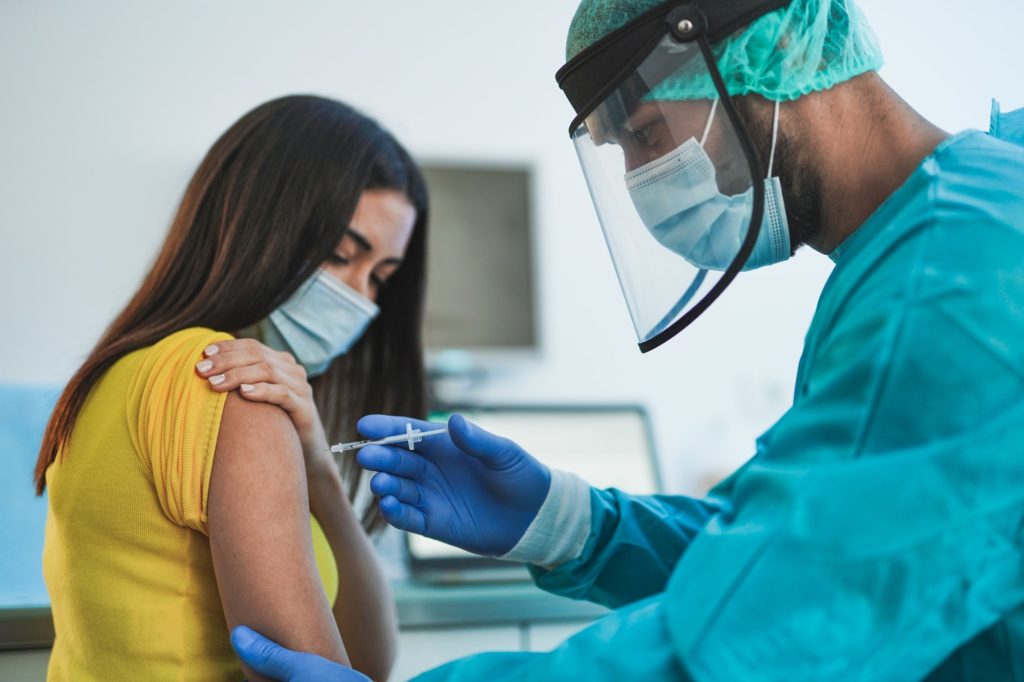 Male doctor or nurse vaccine to a patient's shoulder